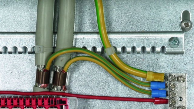 Extremely space-saving shield connection system for use as constant force spring. A spring element compensates the yield of the cable materials.